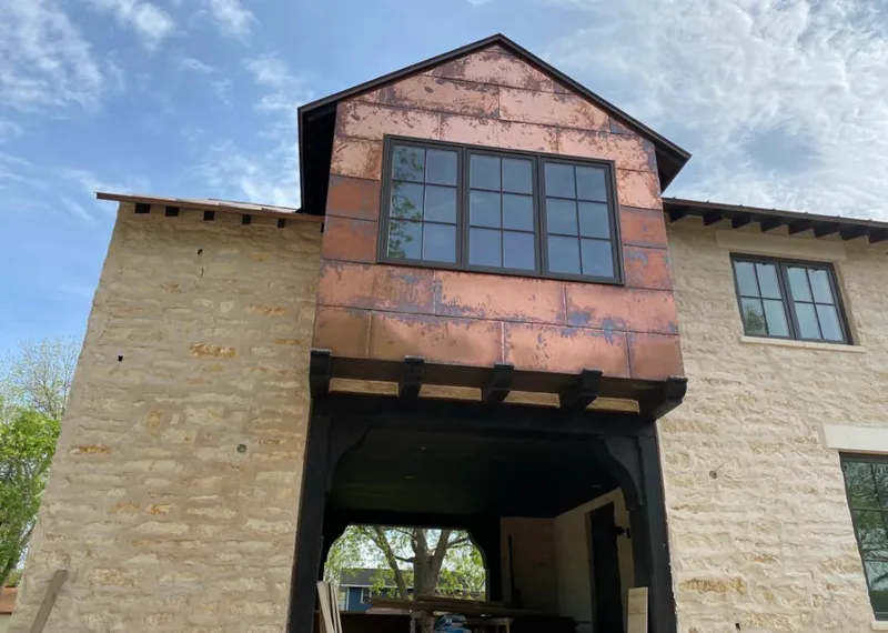 Copper metal panel facade on a stone building for Roof Repair in Garden City