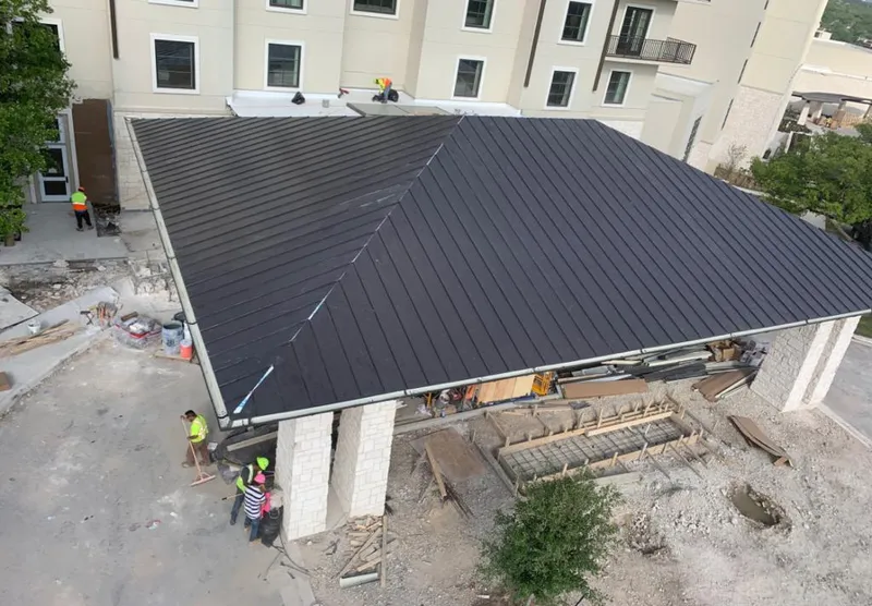 Metal roofing installation team working on a commercial building in Garden City
